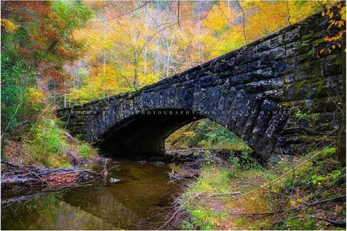 Impresión de fotografía campestre (no enmarcada) Imagen de puente de piedra rodeado de follaje de otoño en el día de otoño en grandes montañas